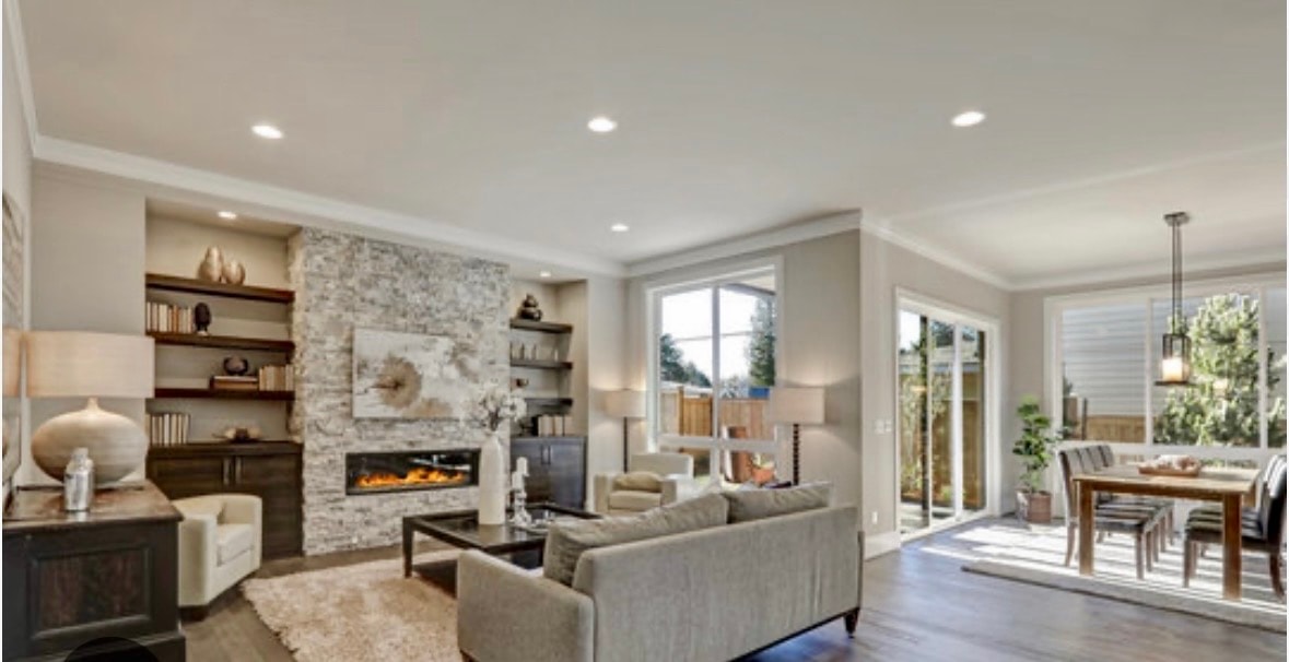 Modern den renovation with stone fireplace, built-in shelving and open dining area