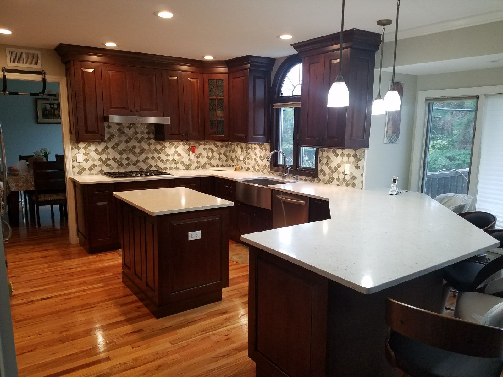 Kitchen remodel with dark cabinetry and quartz island